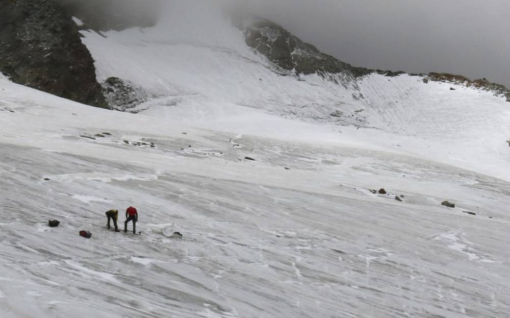 Police investigate the site where the body of a German hiker was found in the Valais canton near Saas-Fee, Switzerland