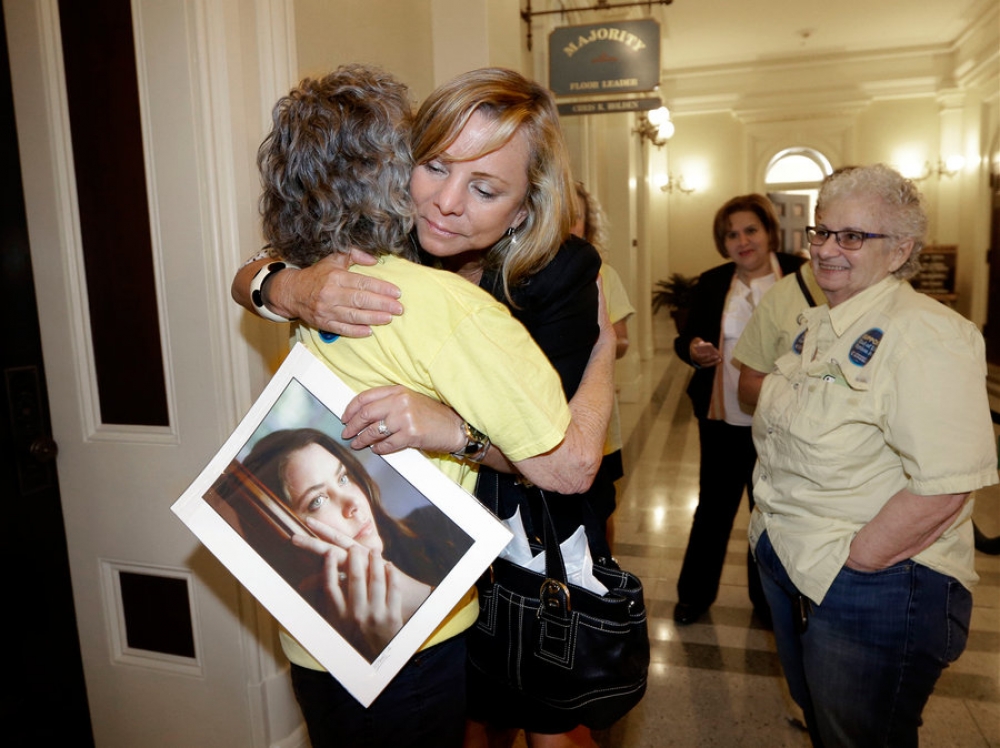 The late Brittany Maynard's mother holds a picture of her daughter after California passed a law to make assisted dying for the terminally ill legal.