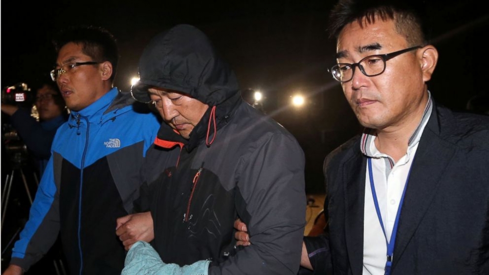 Lee Joon-seok, centre, the captain of the sunken ferry exits court followinh his arrest