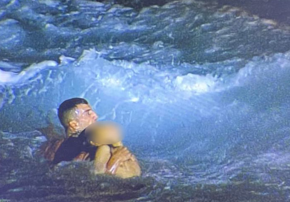 Sean Meli rescues one of the victims caught in the choppy Sliema seas. Screenshot: TVM