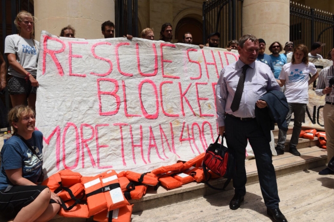 Lifeline captain Claus-Peter Reisch posing with activists from his ship outside the law courts in Valletta