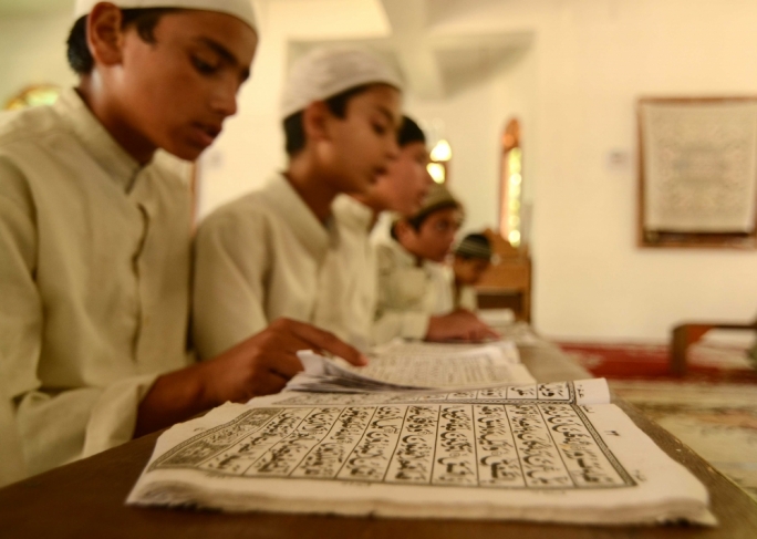 Children reciting the Quran at a religious institute. Photo does not depict the madrassa set up in Malta