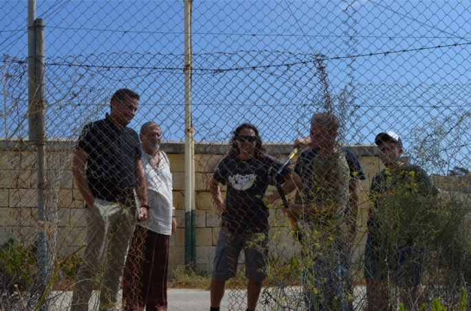 Gzira mayor Conrad Borg Manche and Salvu Mallia look on as KEA activists break through the fence