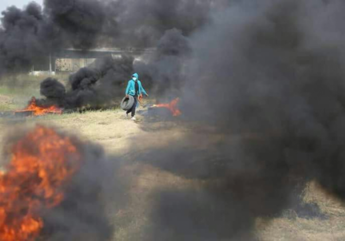 Palestinian protester burning tires