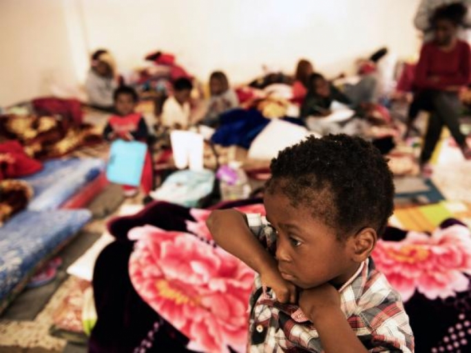 A child stands in a room where women and children sleep on old mattresses laid on the floor at a detention centre, in Libya (Photo: UNICEF)