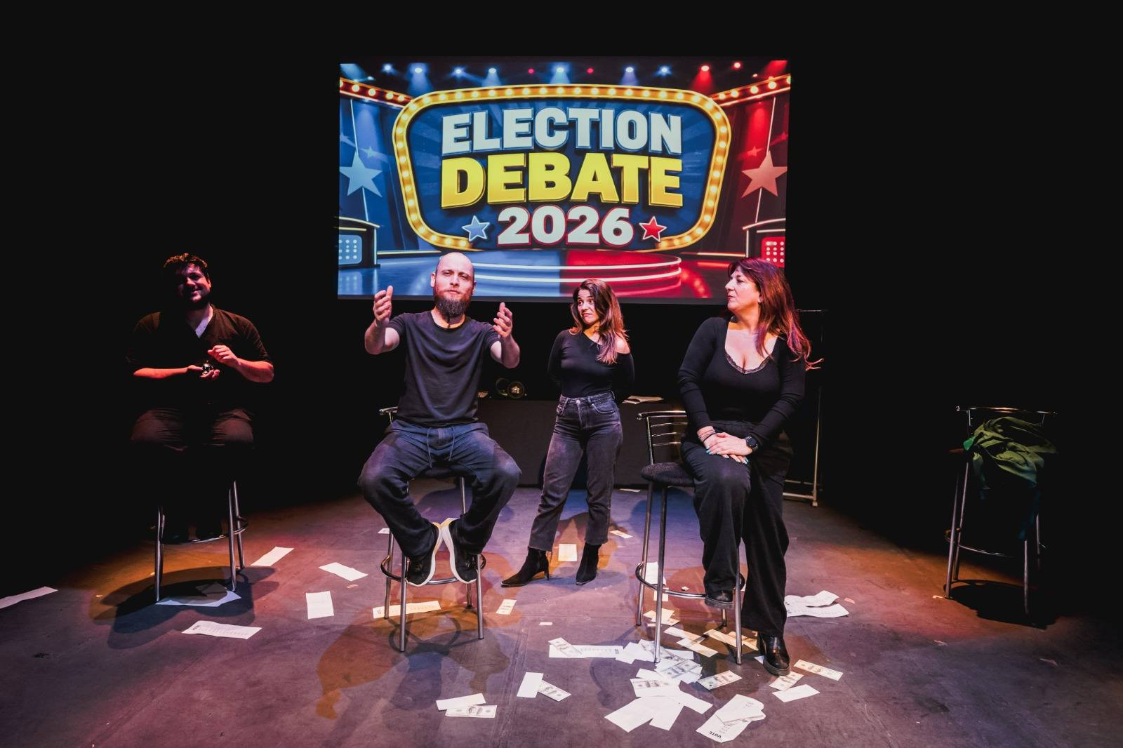 A fake debate pits Sean's Democratic Integrity Campaign for Knowledge, Harmony, Evaluation and Development (DICKHEAD) against Pia's Order of Sovereignty, Harmony, Equality, Nation, Organisation, Reform, Meritocracy and Integrity (OSH ENORMI), with proposals written by the audience. 