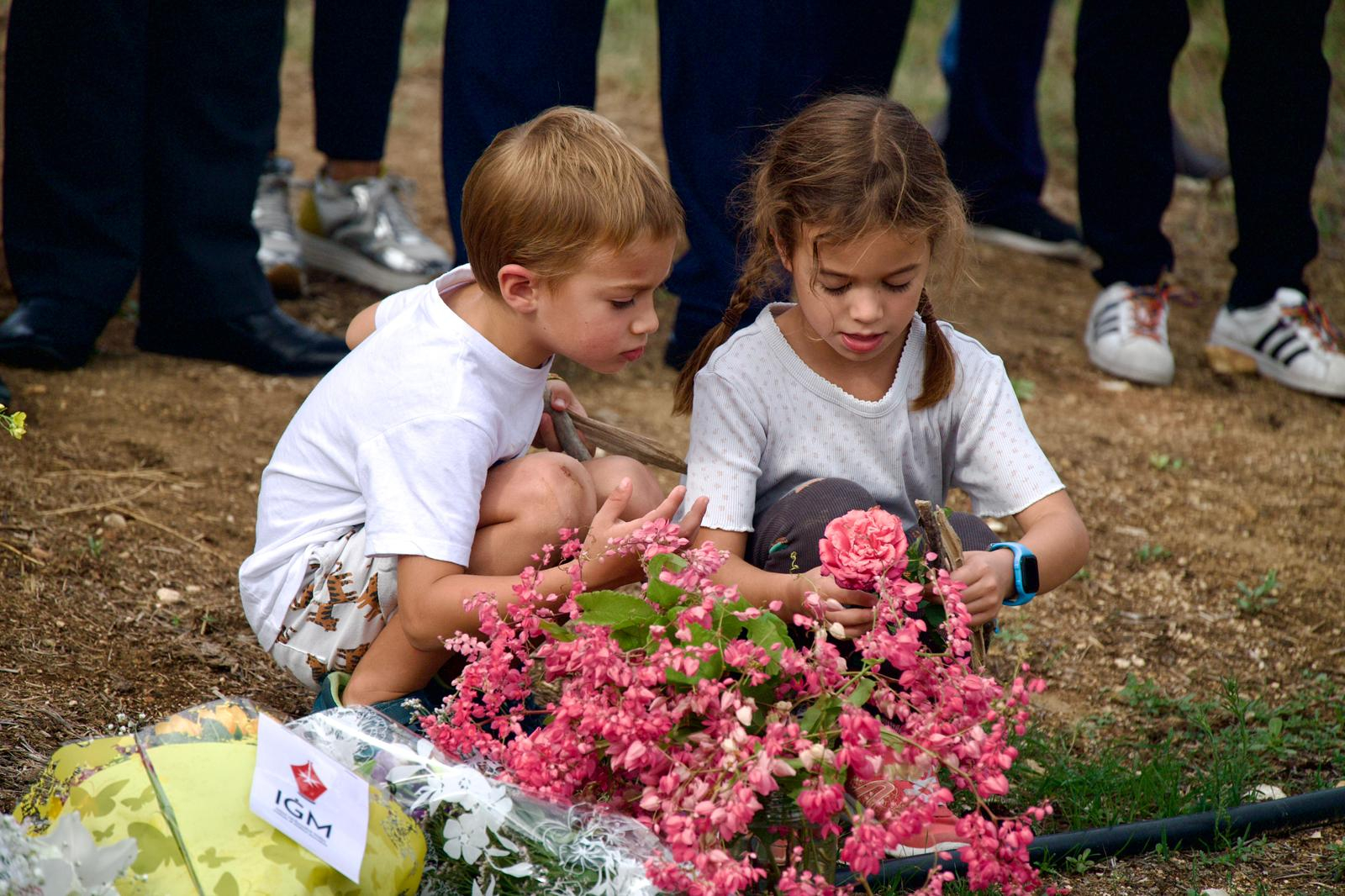 The grandson and grand daughter Daphne never got to see laying pink roses in remembrance of the nanna they never met (Photo: Miguela Xuereb/Newsbook)