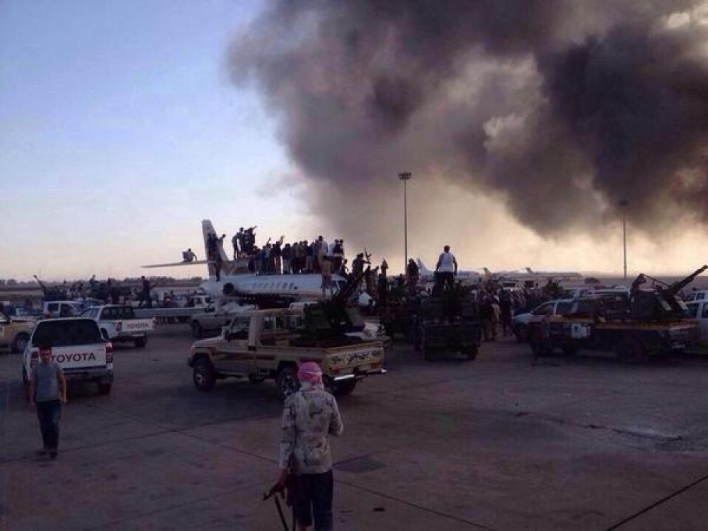 Militia men from the Islamist Dawn (Fajr) coalition celebrate atop a seized aircraft after taking over Tripoli airport