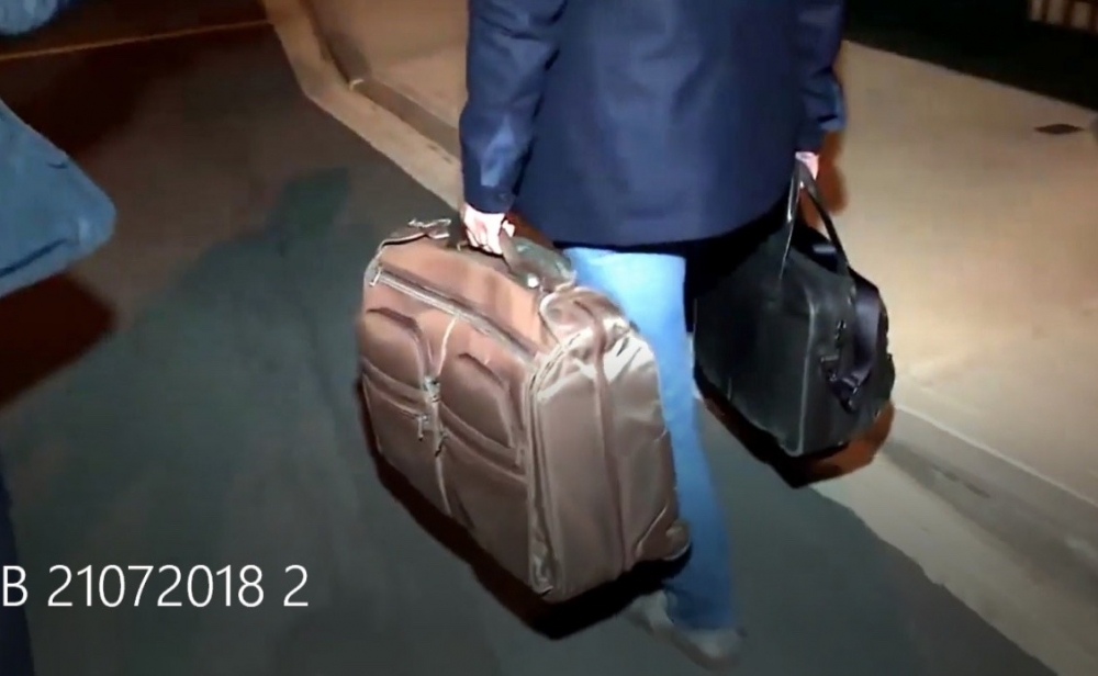 A screen grab from NET TV's footage from a year ago showing the Pilatus Bank chairman exiting the his bank at night with suitcases