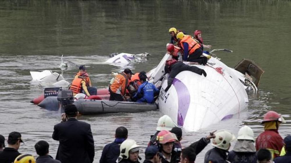 Rescuers work to free passengers trapped inside the plan
