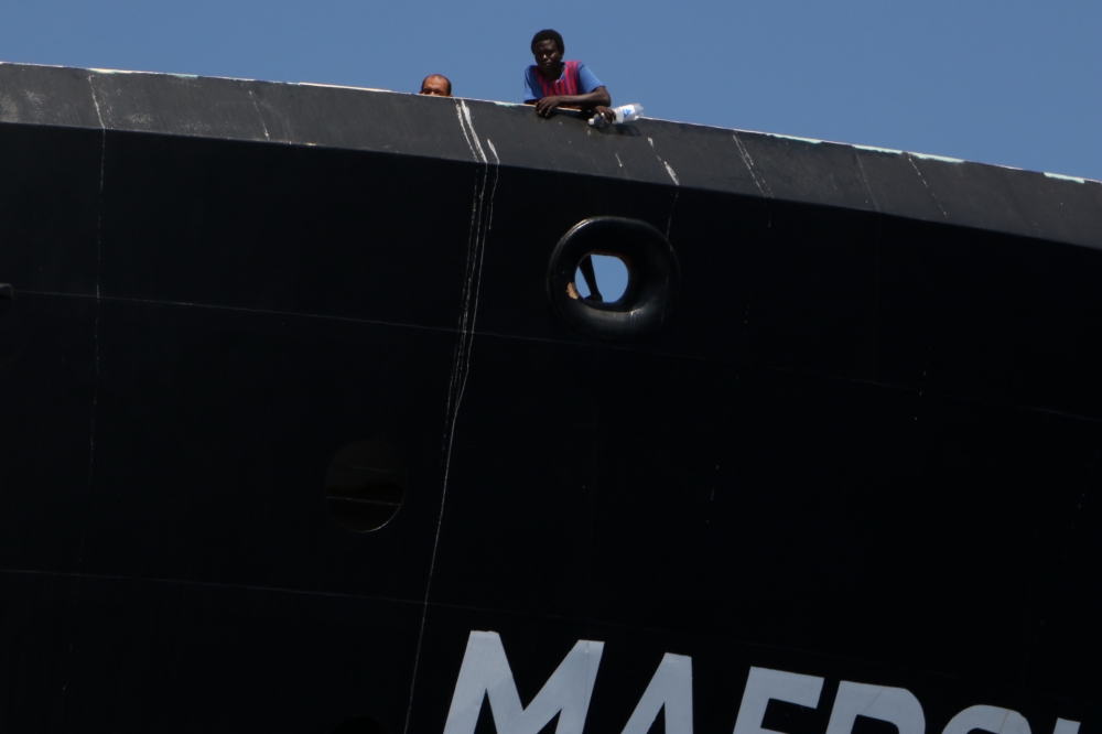 Message in a bottle: One of the migrants aboard the Etienne passes on a message to MaltaToday. Photo: Karl Azzopardi/Mediatoday