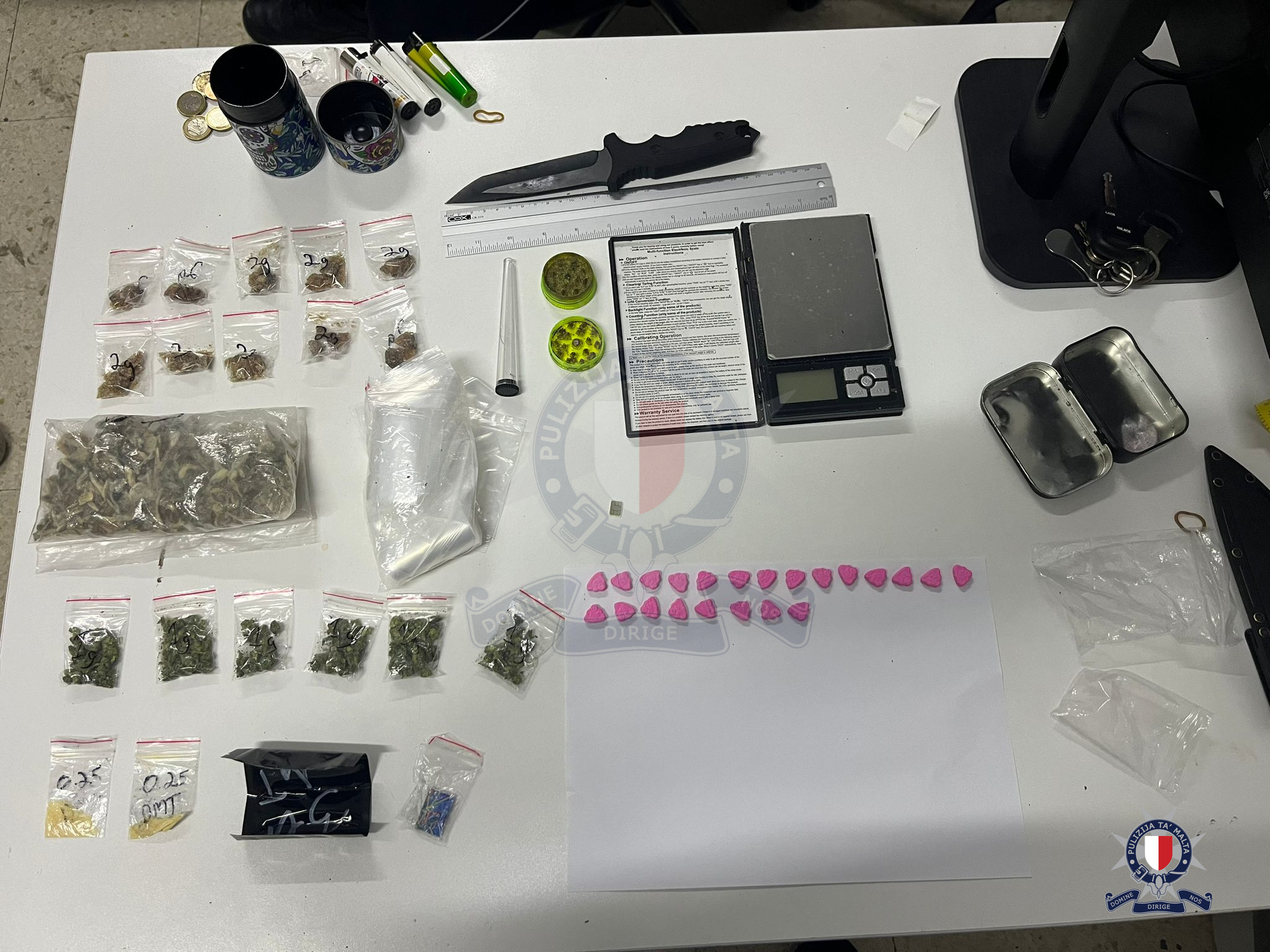 After a search was carried out, a number of substances suspected to be drugs, an electronic scale, around €1,100 in cash and a large knife (Photo: Malta Police)