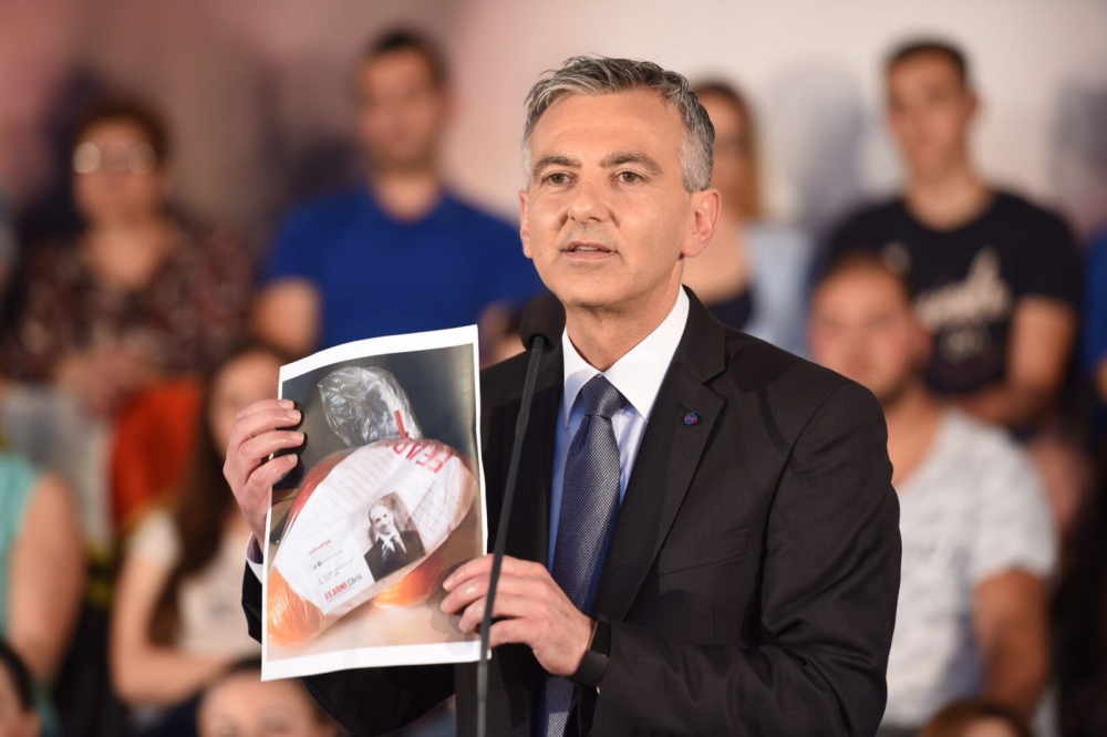 Busuttil holding up a bag of oranges being distributed by Chris Fearne in the fourth district