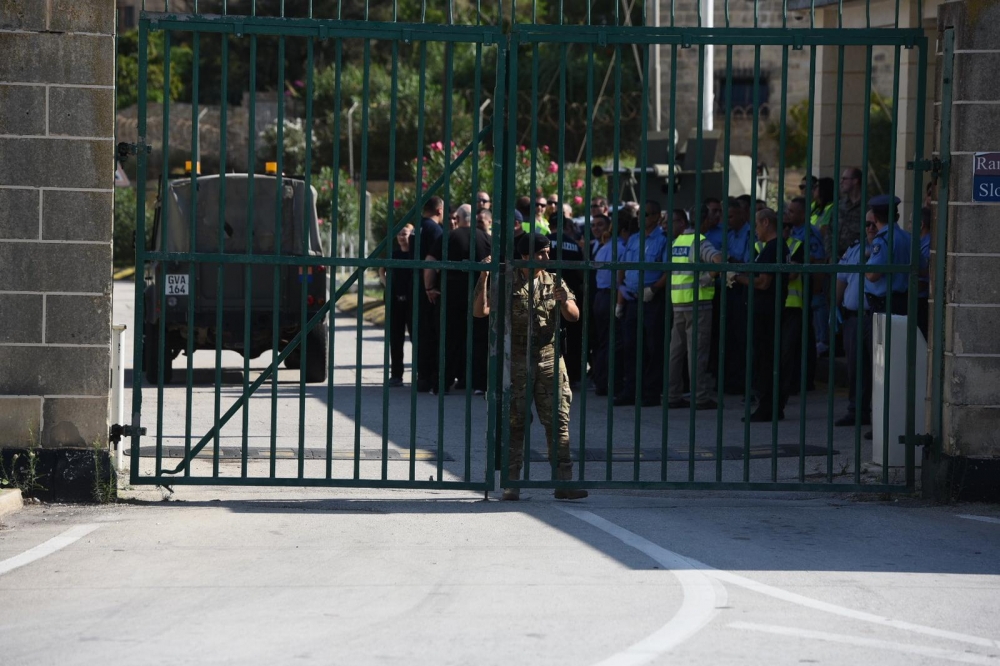 Police officers have gathered at the AFM base a 100 meters away