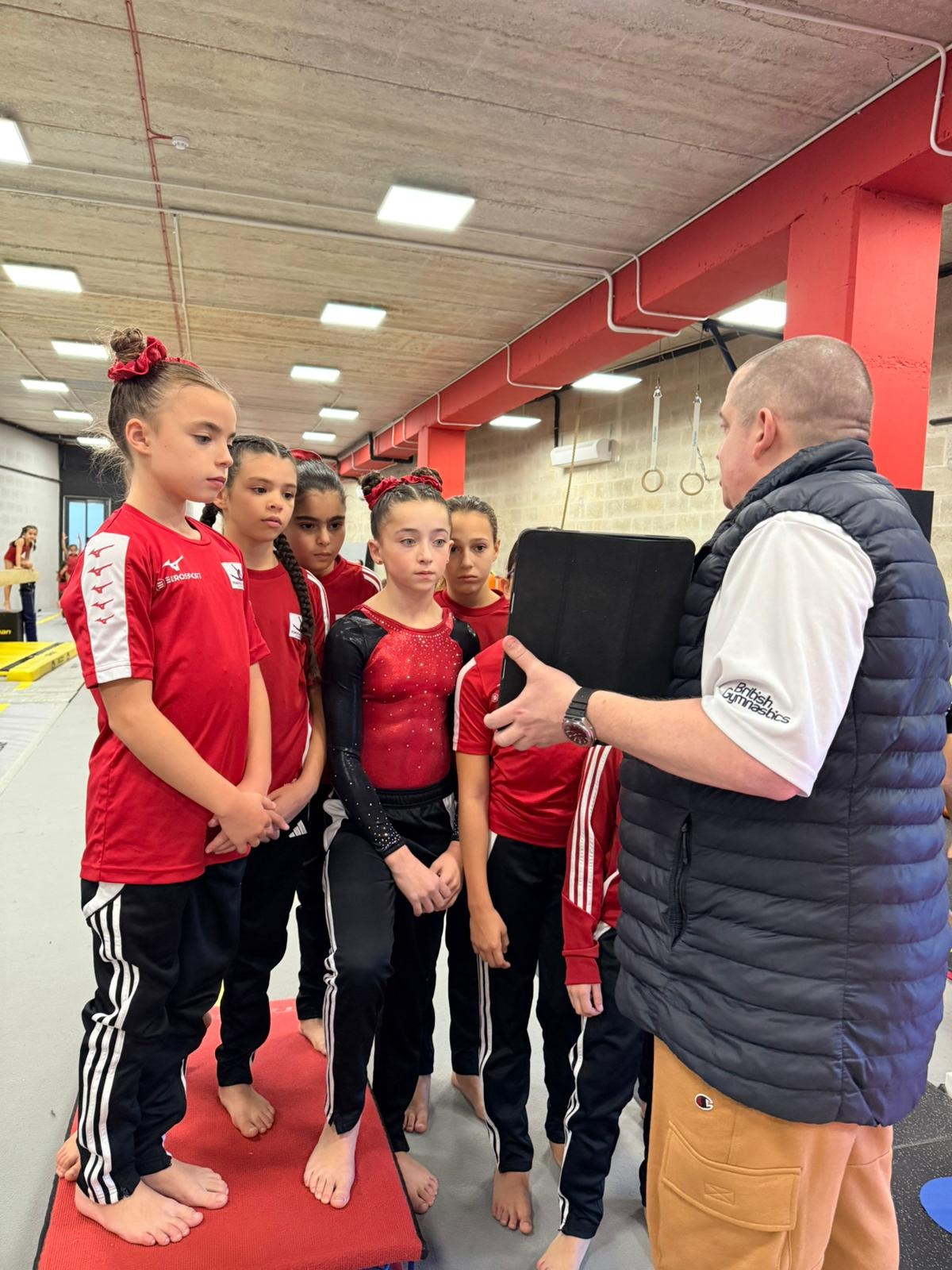 Coach Andrew Paul Buckley handing out instructions to the young gymnasts 