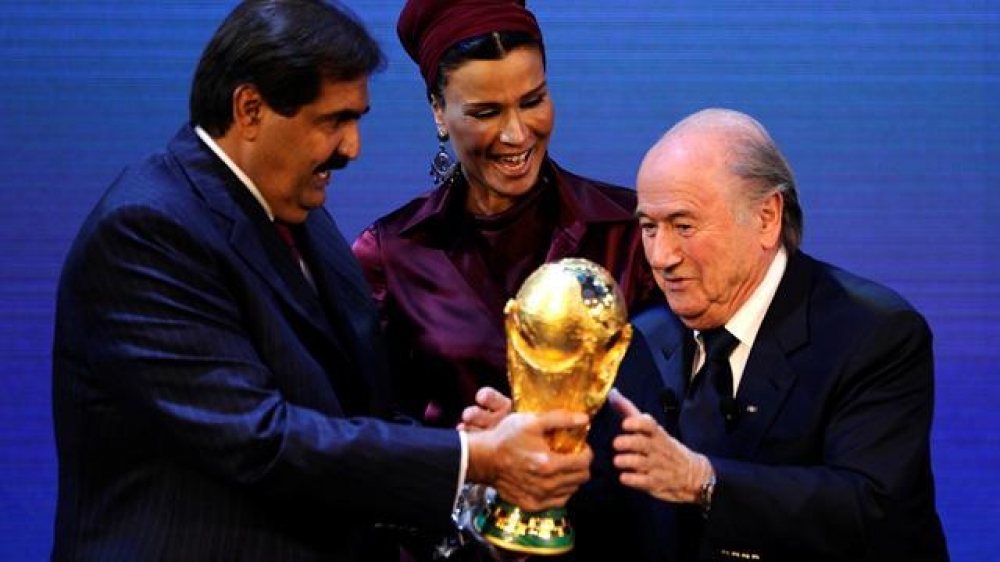 FIFA President Josef Blatter (R) hands over the World Cup trophy to the Emir of the State of Qatar Sheikh Hamad bin Khalifa Al-Thani (L) and his wife Chair of Qatar Foundation for Education, Science and Community development Sheikha Moza bint Nasser Al-Mi 